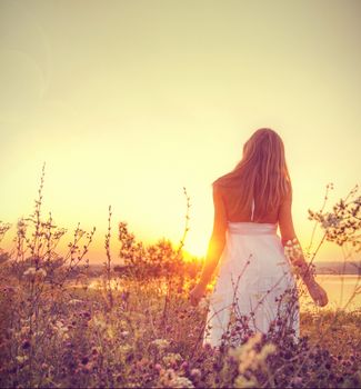 Cute lady walking through the meadow