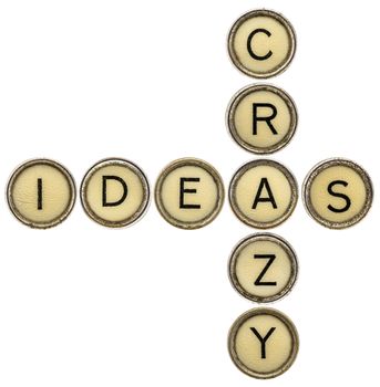 crazy ideas crossword in old round typewriter keys isolated on white