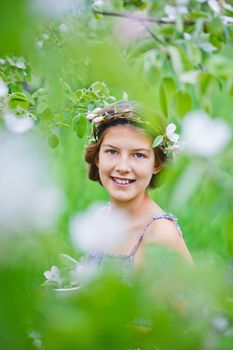 Adorable girl in blooming apple tree garden on spring day