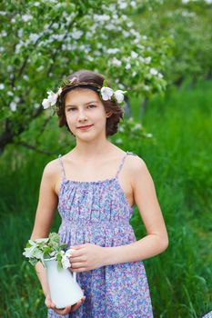 Adorable girl in blooming apple tree garden on spring day