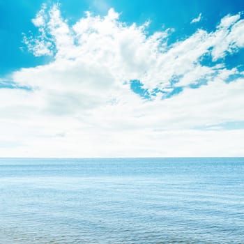 blue sea and white clouds in sky over it