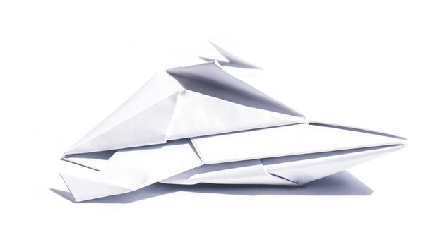 Side view of a nice origami spaceship isolated over a sheet of paper