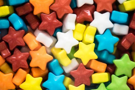 A lot of multicolored little star shape candies closeup 