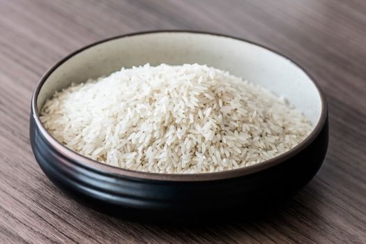 Black bowl full of rice on the table