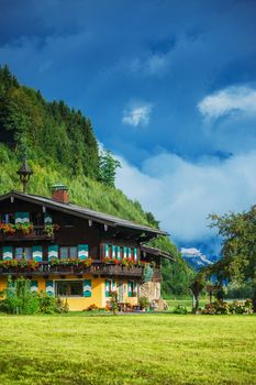 Traditional Austrian house. Summer landscape in Alps.