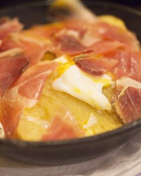 Spanish Serrano sliced ham egg and potato sartenada racion tapas dish photo.