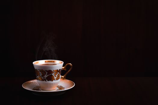 Cup of coffee on a background of dark wood.