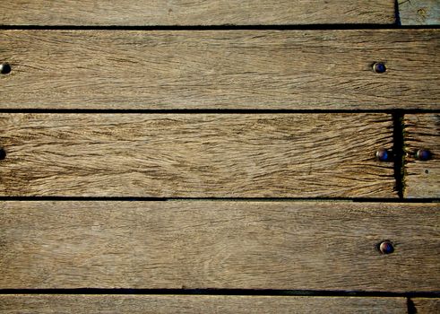 Background of Old Wooden Deck Board with Nail Heads closeup
