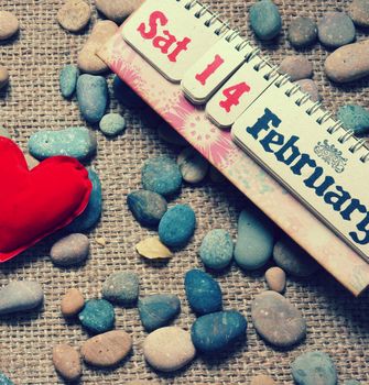 Red heart, symbol of love with desk calendar, Feb 14 on it, nice pebble, fiber  background, with vintage color, Valentine day is special day for lover with sweetheart