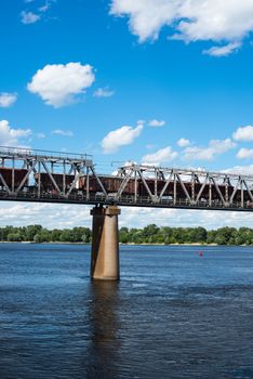 One of the piers supporting the railroad bridge across the Dnieper in Kyiv. Freight train passing across the bridge.