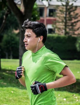 Young man at a local park jogging near home, vertical pic 