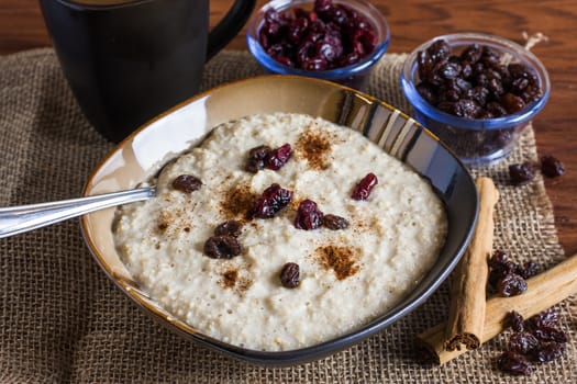 An early morning breakfast of fruit and oats with coffee with morning light reflecting in from the right.