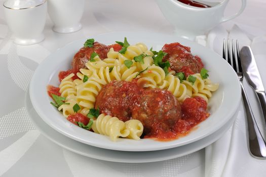 Pasta with meatballs in tomato sauce and herbs