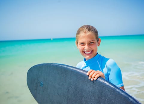 Teenage girl in blue has fun surfing