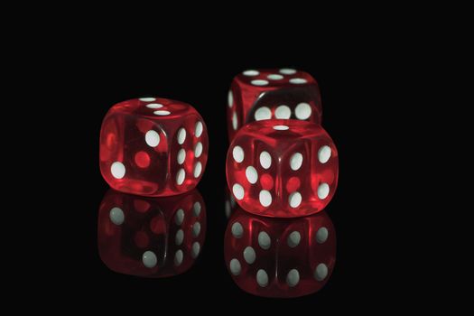 Three red casino dices on the black background