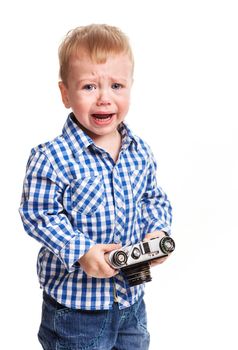 Toddler boy holding camera and crying over white background