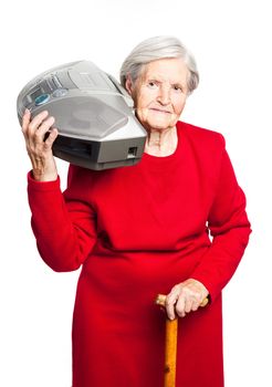 Senior woman listening to music while carrying stereo recorder over white