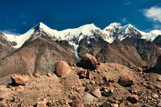 Scenic view of rocks on the edge of Engilchek glacier with picturesque Tian Shan mountain range in Kyrgyzstan