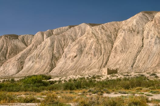 Old ruins of ancient temple under cliff in Kyrgyzstan