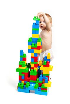 Toddler boy is playing with building blocks over white background