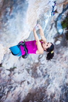 Young female rock climber on a cliff face