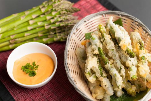 Thai style appetizer of fried tempura asparagus with dipping sauce. 