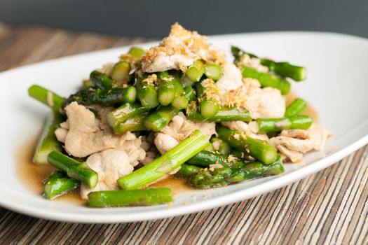 Freshly prepared Asian style chicken and asparagus stir fry with garlic.