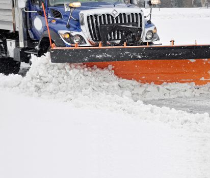 Snow plow clearing streets during a blizzard