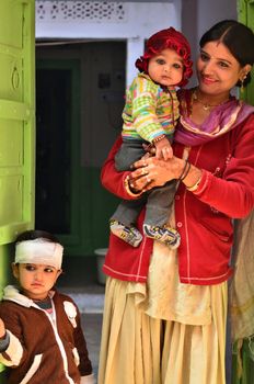 Jodhpur, India - January 1, 2015: Indian proud mother poses with her children in Jodhpur, India. Jodhpur is the second largest city in the Indian state of Rajasthan with over 1 million habitants.