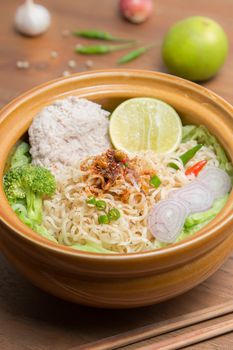 Hot and spicy noodle with pork and vegetables on the wood background