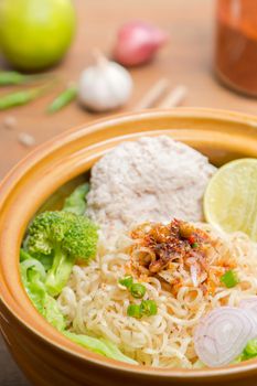 Hot and spicy noodle with pork and vegetables on the wood background