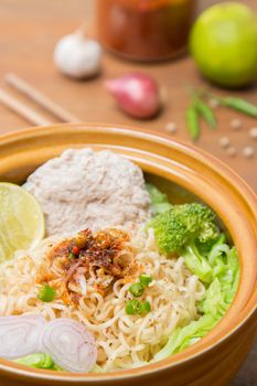 Hot and spicy noodle with pork and vegetables on the wood background