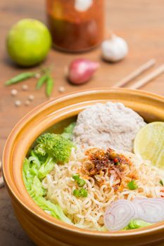 Hot and spicy noodle with pork and vegetables on the wood background