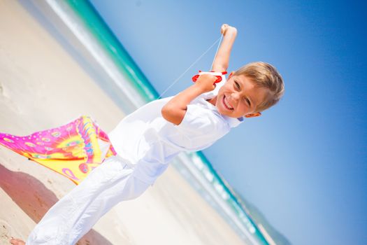 Summer vacation - Cute boy flying kite beach outdoor.