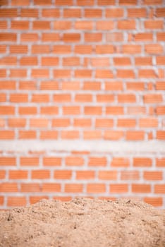 sand and brick wall in background