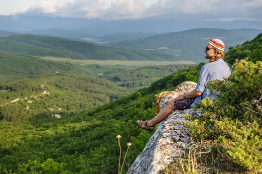 Young hiking man in the rays of sunset, at the top of Tope Kermen cliff, Crimea, Ukraine