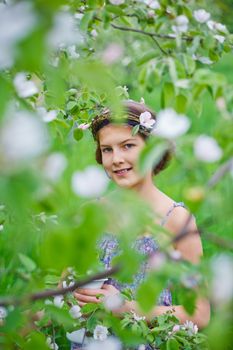 Adorable girl in blooming apple tree garden on spring day