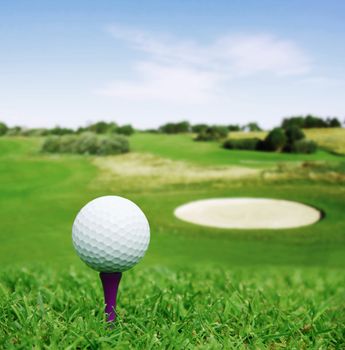 Golf ball on course with beautiful blurry landscape on background