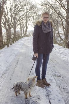young girl with her dog on the snow in winter