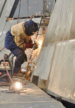 woman worker grinding a ship