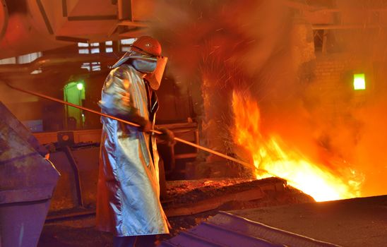 worker and production of cast iron inside of steel plant