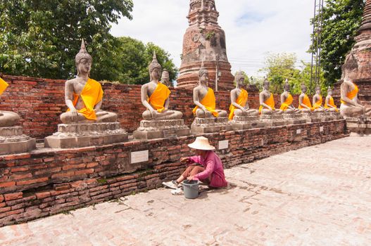 AYUTTHAYA,THAILAND-JUNE 27,2013: Walking around watyaichaimongkol .Some one like to preserve the 
archaeological site 
by pull or drag weed or unwanted flora