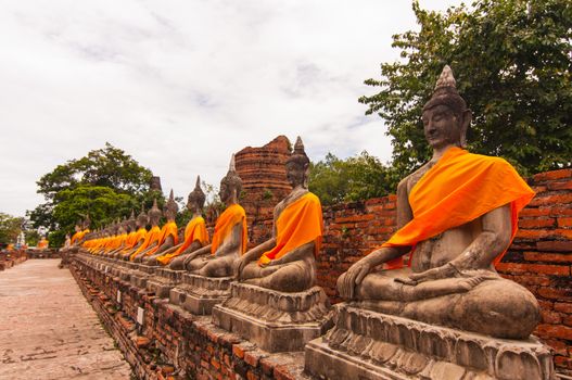AYUTTHAYA,THAILAND-JUNE 27, 2013: Aligned statues of Buddha in Watyaichaimongkol