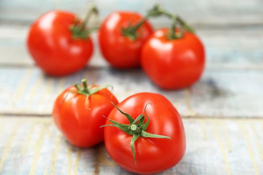 branch with fresh raw tomatoes on wooden background