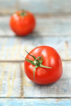 two fresh raw tomatoes on  blue old wooden background