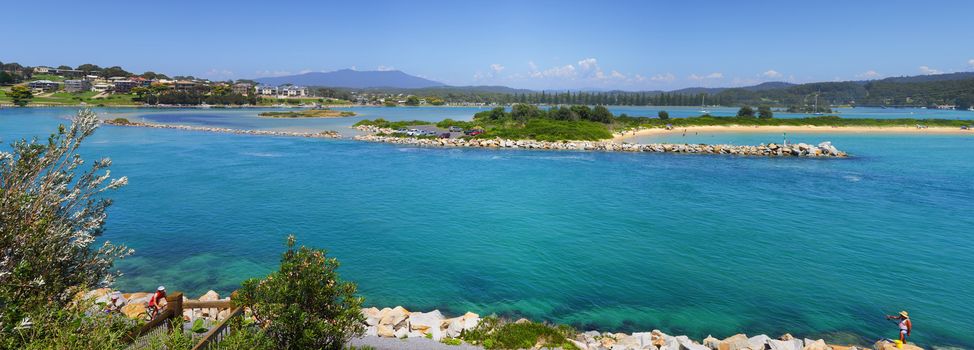 Holidaymakers on vacation, fish, swim, cycle, kayak, sail or sight seeing on the beautiful south coast of Narooma. Mt Gulaga ( Mt Dromedary ) in the far distance.  5 image stitched panorama