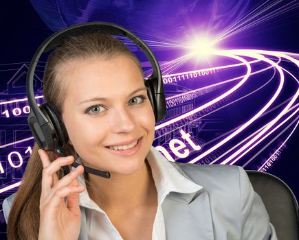 Closeup of businesswoman in headset, her hand on microphone, looking at camera, smiling. Wire-frame building with light as backfrop