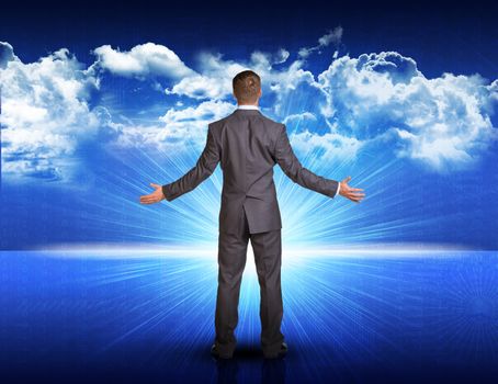 Businessman standing with his arms spread against digitally generated spacy blue landscape with rising sun and cloudy sky 