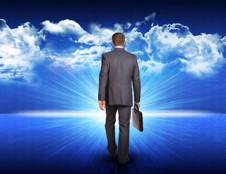 Businessman with briefcase walking against digitally generated spacy blue landscape with rising sun and cloudy sky 