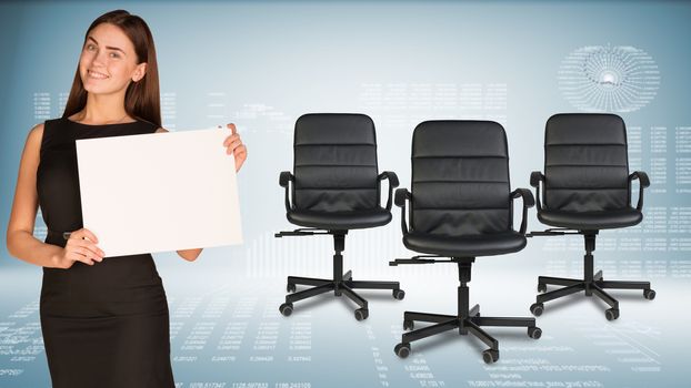 Businesswoman holding blank white paper sheet, looking at camera, smiling. Three office chairs beside. Hi-tech graphs as backdrop